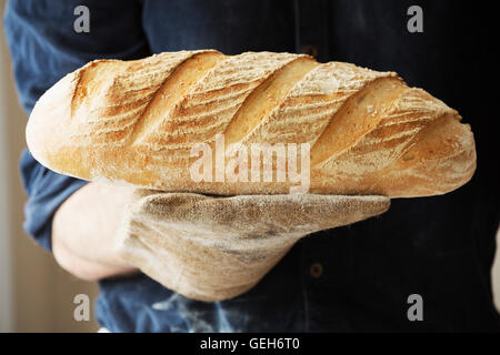 Baker holding two freshly baked loaves of bread. Stock Photo