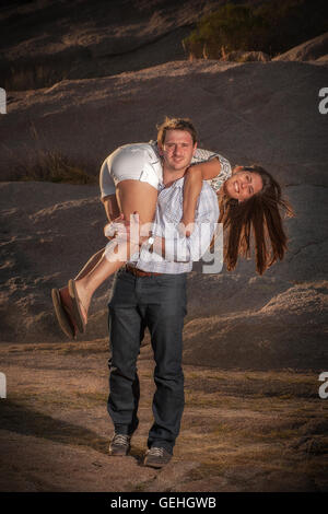 Man walks carrying his girlfriend on his shoulder Stock Photo