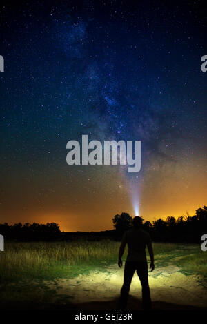 Man explorer looking up to the Milky Way galaxy Stock Photo