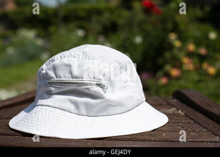 A floppy sun hat hanging on a person's 
