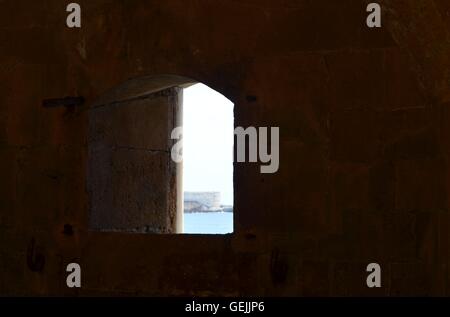 Sea view through the fortification window at the Castello Maniace in Ortigia, Siracuse in Sicily. Stock Photo