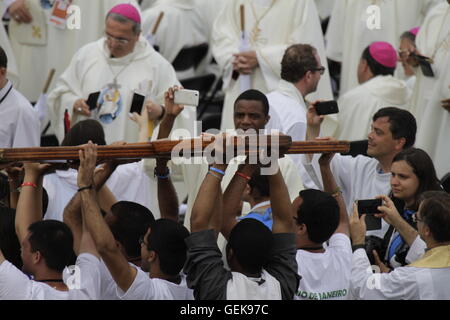Krakow, Poland. 26th July 2016. Young pilgrims carry the cross for the main altar towards the altar. Tens of thousands of young pilgrims came to the opening mass of the World Youth Day 2016 to the Blonia park in Krakow. The mass was celebrated by Cardinal Stanislaw Dziwisz, the Archbishop of Krakow. Credit:  Michael Debets/Alamy Live News Stock Photo