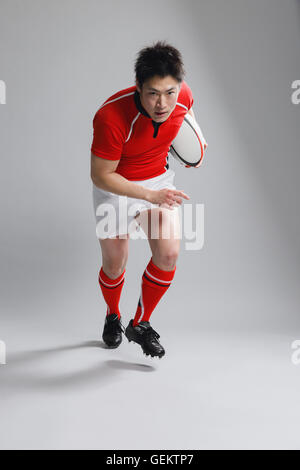Portrait of Japanese rugby player running with ball Stock Photo