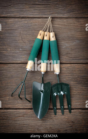 gardening tools hanging on wooden plank background Stock Photo