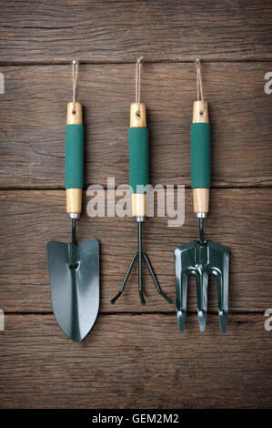 gardening tools hanging on wooden plank background Stock Photo