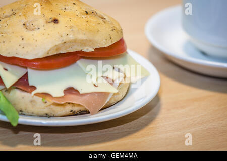 Breakfast ham, cheese and tomato bun on a plate Stock Photo