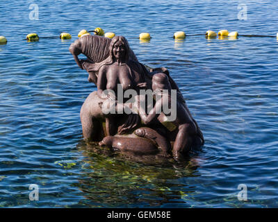 Stone statue of woman child polar bear walrus seal fish Colony harbour Sissiugaq Bay in old colonial district Nuuk capital city of Greenland Stock Photo