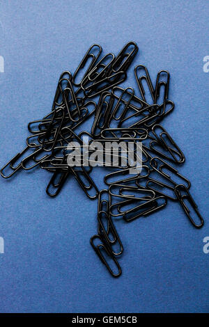 Close up of black paper clips on a plain background Stock Photo