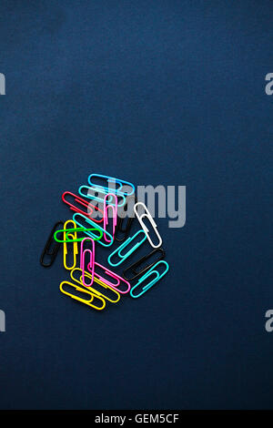 Multi coloured paper clips on plain background Stock Photo