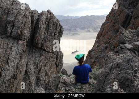 Female hiker surrounded by rocks in Death Valley, USA Stock Photo