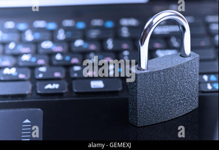 Data security concept with padlock on laptop computer keyboard. Toned in blue Stock Photo
