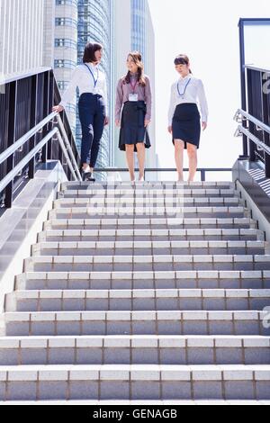 Business women going down the stairs at downtown area Stock Photo