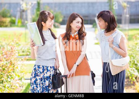 Women talking while seeing a map Stock Photo