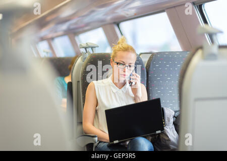 Business woman working while travelling by train. Stock Photo