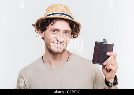 Close-up portrait of a happy young man holding alcohol flask isolated on the white background Stock Photo