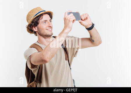 Happy young smiling man with backpack making selfie isolated on a white background Stock Photo