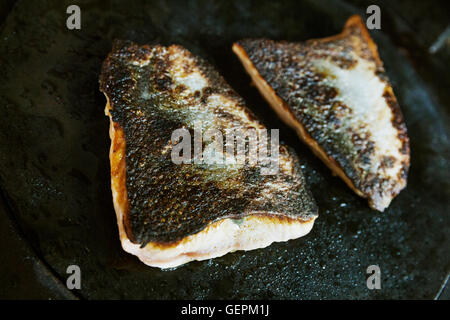 Close up of a pan-fried fillet of fish with crispy skin. Stock Photo