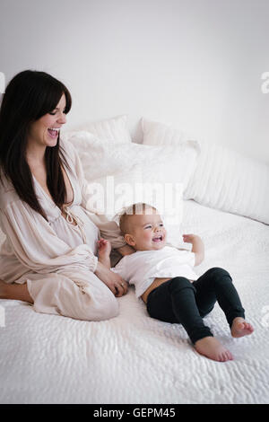 A heavily pregnant woman playing with her young son. Stock Photo