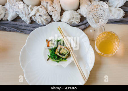 Overhead view of plates of sushi and a table setting for a celebration meal. Stock Photo