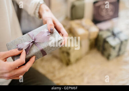 A woman holding a gift wrapped present. Stock Photo