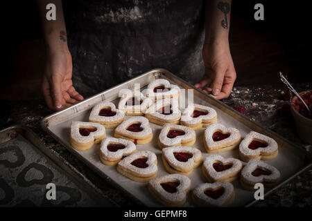 Valentine's Day baking, high angle view of a baking tray with heart shaped biscuits. Stock Photo
