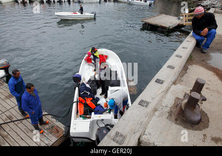 Family from an outlying area in a small boat in the harbor, Ilulissat, Greenland Stock Photo