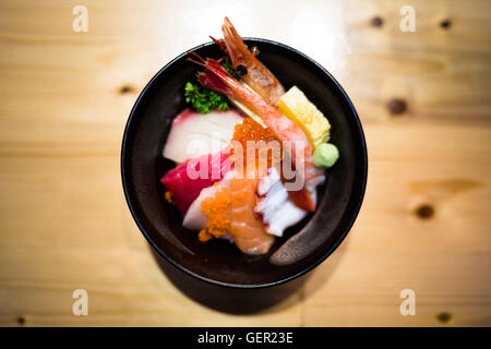 Chirashi sushi, Japanese food with raw salmon sashimi, mixed seafood, top view, darken edge, center aligned with copy space Stock Photo