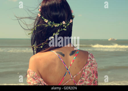 Beautiful woman wearing a garland next to the sea Stock Photo