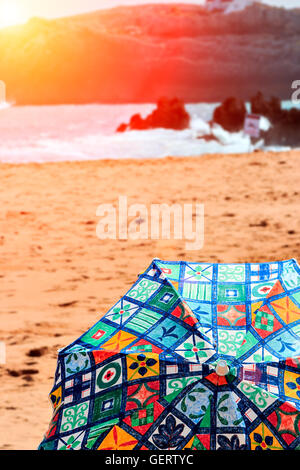 Beach umbrella at sunset on a beach in Cantabria, Spain. Vertical image. Stock Photo