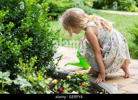 Cute little girl watering plants in the garden Stock Photo