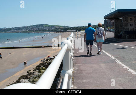 A couple walking along Colwyn Bay promenade Stock Photo