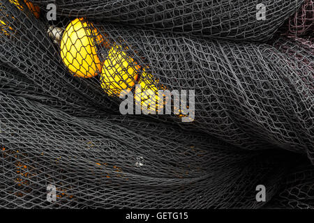 Black fishing net with yellow corks in Santona harbour, Cantabria, Spain. Horizontal image. Stock Photo