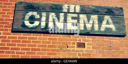 Film and Television Institute sign on weathered wooden planks against and red brick background in Fremantle, Western Australia.