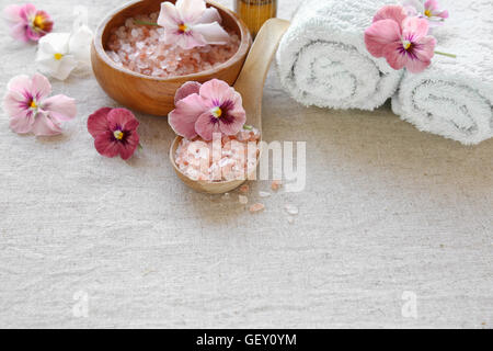 Pink sea salt and flowers, Spa setting, copy space background, selective focus Stock Photo