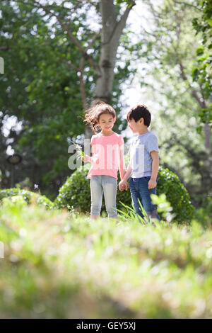 Happy Chinese children holding hands running in woods Stock Photo - Alamy