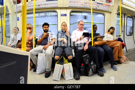 London, England, UK. People on the Tube / underground, all looking at mobile phones / iPads Stock Photo
