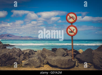 No swimming, no fishing signs on the coast in Corralejo, Fuerteventura, Canary Islands, Spain Stock Photo