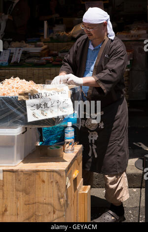 The outer market at the tsukiji fish market in Tokyo, Japan. Tradesmen prepare fresh seafood and sell it to visitors.