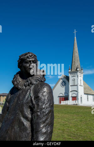 Alaska, Seward Peninsula, Nome, Anvil City Square. Statue of 'The Two Eskimo Boys' in front of the historic Old St. Joseph Hall. Stock Photo