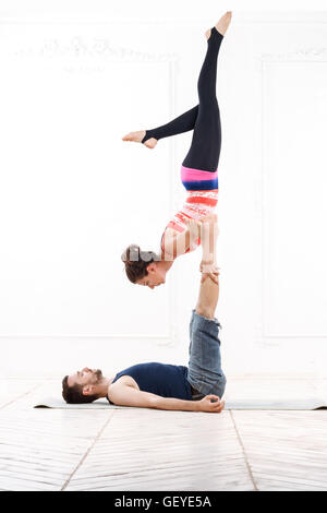 Beautiful Young Couple Practicing Acro-Yoga Stock Photo
