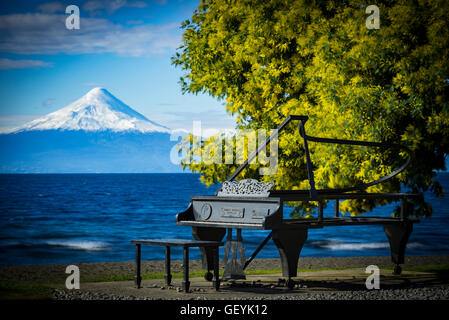 Frutillar, piano de metal en la costanera, Los Lagos, Chile. Metal Piano in front Osorno Volcano. Stock Photo