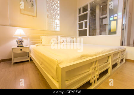 Abstract bedroom in warm light colors. big comfortable double bed in elegant classic bedroom Stock Photo
