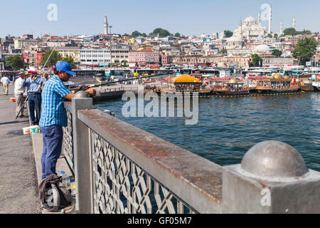 Istanbul, Turkey - July 1, 2016: Fisherman on Galata bridge over Golden Horn in Istanbul, Turkey Stock Photo