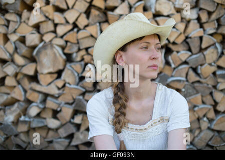 young girl in a cowboy hat on  background of wood Stock Photo