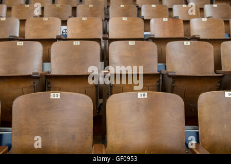 Antique Wood Auditorium Seat Backs Straight on View with two chairs in front Stock Photo