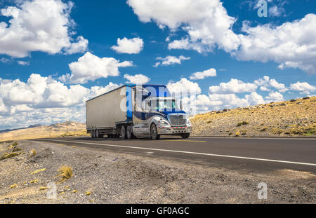 Blue truck moving on a highway Stock Photo