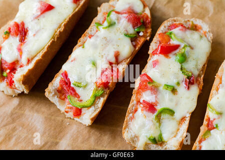 Baguette pizza sandwiches on parchment paper, close up view Stock Photo