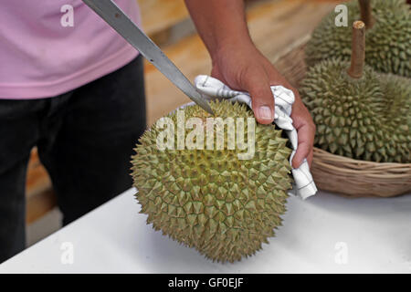 vendor peeling durian for customer in fruit market Stock Photo