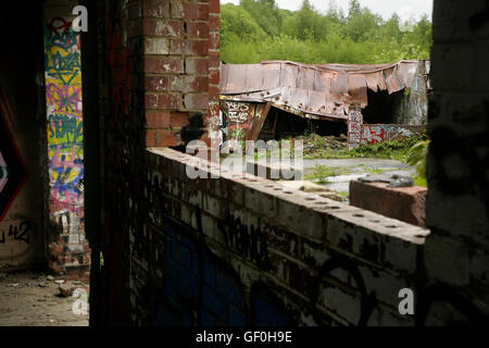 Graffiti and vandalism in abandoned derelict industrial building. Stock Photo