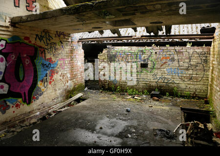 Graffiti and vandalism in abandoned derelict industrial building. Stock Photo